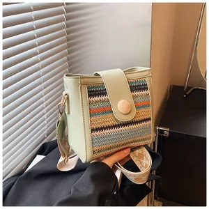 Detailed view of the women woven bucket bag featuring colorful patterns and wide strap.