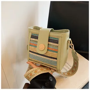 Detailed view of the woven bucket handbag with wide strap, showcasing intricate multi-color pattern.