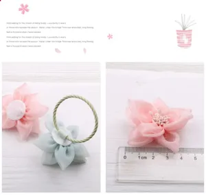 Detailansicht des Mesh-Stoff-Blumen Haaraccessoires zeigt Textur und Größe mit Lineal.