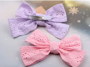 Detailansicht der Spitzen-Schleifen-Haarklammer in Lila und Rosa mit Metallclip, weich.