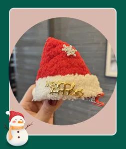 Detalle en primer plano del pasador de pelo de gorro de navidad rojo con borde de felpa y metal.