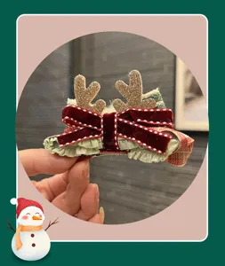 Christmas reindeer hair clip with red velvet bow and glitter antlers for kids holiday accessory.