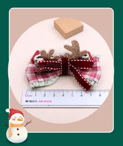 Nahaufnahme der Weihnachts-Karo-Schleife Haarklammer mit Rentiergeweih und Samt.
