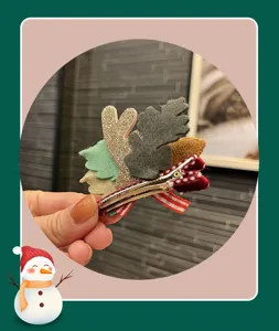 Close-up detail shot of Christmas deer antler hair clip with cute felt leaves and ribbon.
