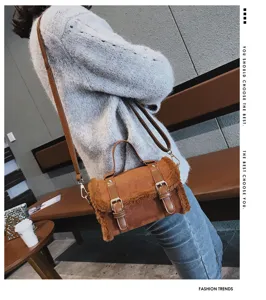 Close-up detail of the brown faux suede and plush crossbody bag showcasing stylish dual buckles.