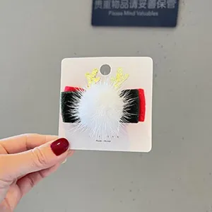 Nahaufnahme des Weihnachts Haarspangen Details mit weissem Pluschpompon und Geweih.