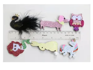 Detailansicht niedlicher Glitzer Cartoon Haarklammern und DIY Accessoires in tollen Formen.