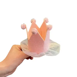 Kids pink birthday crown hat with fluffy pom-poms and shimmering tulle mesh party hair accessory.