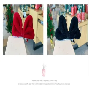 Velvet bow hair clip detail view showing red and black options with metallic clip.