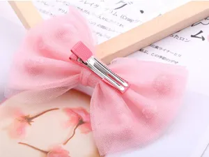 Vista ravvicinata del grazioso fermaglio per capelli con fiocco in rete rosa per bambini.