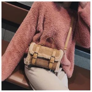 Brown plush shoulder bag detail showing the soft faux shearling trim and stylish buckles.