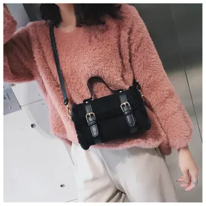 Black plush crossbody bag detail shot, featuring stylish dual buckle design and cozy texture.
