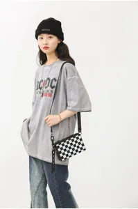 Vue détaillée du sac bandoulière carré à motif damier style coréen avec grosse chaîne.