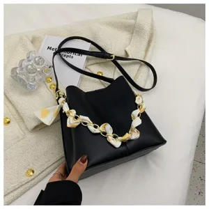 Detailaufnahme der schwarzen Beuteltasche mit edler Kette, Seidentuch und hochwertiger Lederoptik.