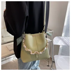 Grüne Beuteltasche Detail mit stylischer Kette und Seidentuch Griff für den Sommer Alltag.