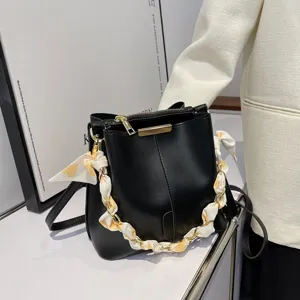 Schwarze Beuteltasche für Damen mit schicker Kette und Seidenschal, stylische Umhängetasche.