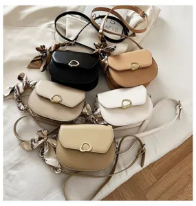 Detailansicht stilvoller Vintage Satteltaschen in verschiedenen Farben mit Seidenschal.