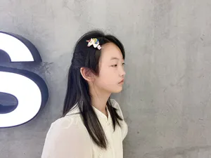 Nahaufnahme eines niedlichen Glitzer-Einhorn-Haarclips, getragen von einem Kindermodel.