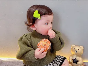 Süßes grünes Herz Haarspange Detailfoto, zeigt süße Baby Alltagsmode und schöne Frisur.