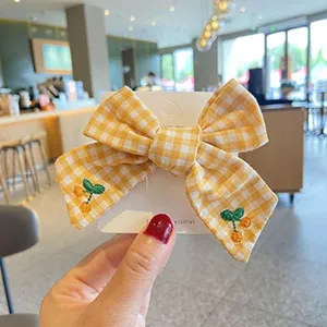 Children hair clip cute yellow checkered bow hairpin with embroidered cherry design detail.