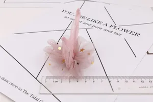 Vue détaillée de la pince à cheveux en tulle rose avec étoiles dorées pour loisirs.