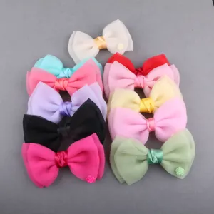 Nahaufnahme zeigt bunte handgemachte Chiffon-Schleifen-Haarspangen und kleine Blumen-Charms.