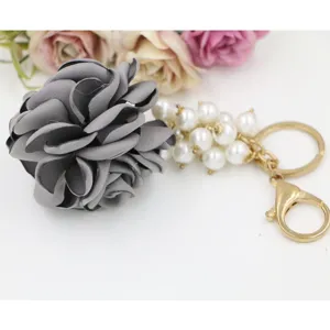 Handgefertigte Stoffrose Detailansicht, elegante Perlenkette mit goldenem Schlüsselanhänger.