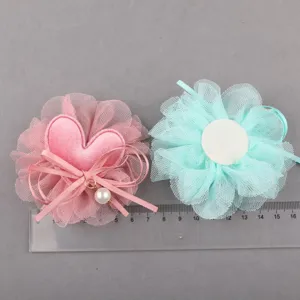 Detailansicht von Netzstoff Blumen mit herzigem Perlenanhänger für schöne DIY Haarschmuckteile.