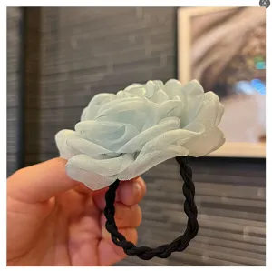 Close-up of light blue organza camellia hair tie, showing 3D handmade floral texture detail.
