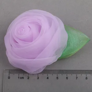 Detailed view of the light purple fabric rose flower with green leaf, handmade DIY accessory.