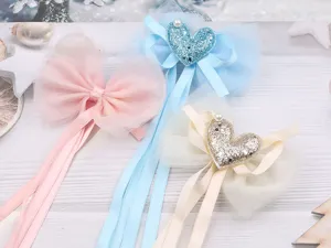 Close-up detail view of cute children hair clips featuring mesh bows, ribbons and glitter heart.