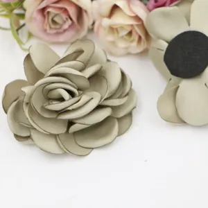 Detailansicht handgemachter Stoff-Rosenblüten DIY Accessoires in Grau-Grün für Basteln.