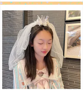 Close-up detail of children princess crown veil hair hoop, elegant white mesh design