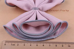 Detailansicht von DIY rosa Haarschleife Material mit grauer Overlock Kante und Lineal.