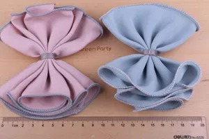 Nahaufnahme von großen Stoff-Schleifen-Accessoires in Rosa und Blau mit sauberer Kante.