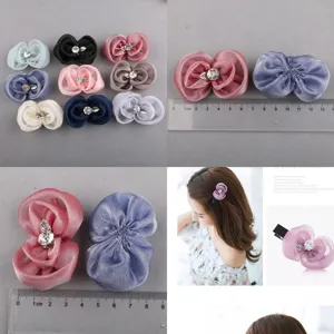 Nahaufnahme von handgefertigten Organza-Blumen-Haarspangen mit funkelnden Strasssteinen.
