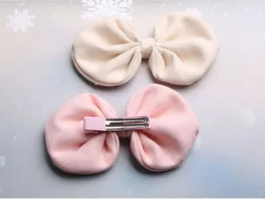 Detailed view of cute fabric bow hair clips, showing soft texture and metal clip.