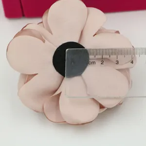 Handgemachte Stoffblume Detailaufnahme, rosa Blumenaccessoire nahaufnahme mit Lineal.
