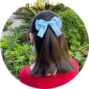 Primer plano del detalle del bonito pasador de pelo con lazo azul claro de tul para niños.