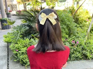 Vista detallada del bonito pasador de pelo con lazo amarillo y tul blanco para niñas.