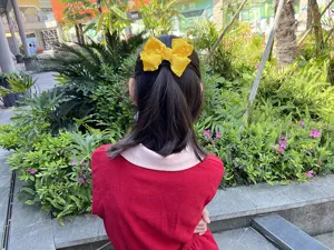 Yellow fabric bow hair clip detail shot, perfect for sweet girls' cute daily hairstyles.