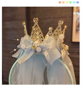 Close-up detail of children crystal crown headband with blue bow and pearls for party.
