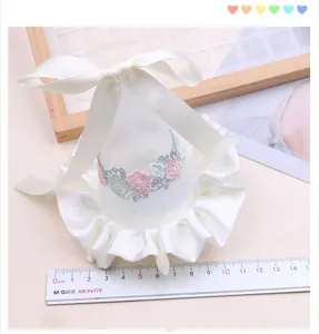 Detailed view of children white lace princess hat with ribbon bow and floral embroidery for photo.