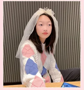 Gros plan détail du voile de mariée blanc et de la mini tiare pour filles en photo.