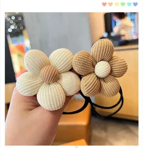 Kordfleur Haargummi Detail Nahaufnahme, weiche Stoffstruktur, niedliches Blumen Design Zubehör.