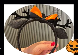 Detail of Halloween party headband with black orange bow, antlers, and mesh for kids dress up.