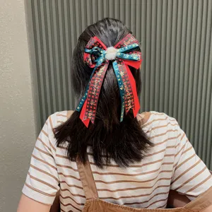 Christmas hair bow clip with red green plaid ribbons, festive fluffy ball hair accessory.