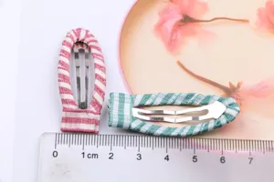Stoffbezogene Klick-Haarspangen im Set mit rosa Streifen und grünem Karomuster für DIY-Zubehör.