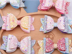 Nahaufnahme der bunten Glitzer-Schleifen-Haarspangen, präsentiert auf einem Holzteller.