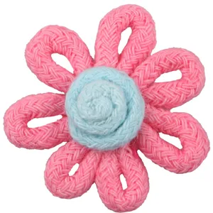 Detailed view of handmade knitted pink flower accessory with blue center for DIY crafts and decor.